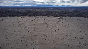 Lagoons Prints: Aerial view of Icelandic volcanic desert landscape with dark lava fields stretching to the horizon under a cloudy sky