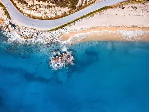 Coast Road Prints: Aerial view of an idyllic sea sandy beach with asphalt winding road and rocky cliff