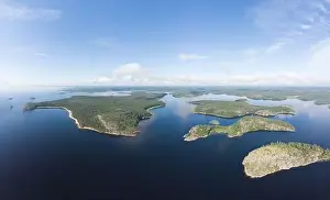 Aerial top view to island Kilpola overgrown with sparse trees in summer sunny day