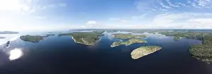 Aerial top view to island Kilpola overgrown with sparse trees in summer sunny day