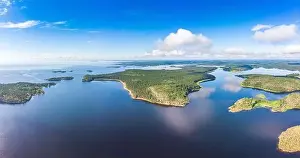 Aerial top view to island Kilpola overgrown with sparse trees in summer sunny day