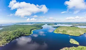 Aerial top view to island Kilpola overgrown with sparse trees in summer sunny day