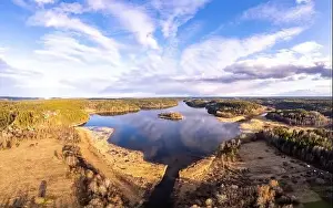 Mountain River Prints: Aerial top view to island overgrown with sparse trees in summer sunny day