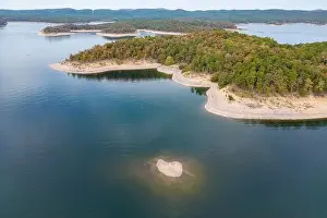 Aerial view of landscape of water of Broken Bow lake and islands with forest on the bank