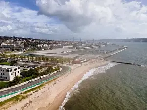Aerial view of Lisbon southern coastline following Tagus river with April 25th bridge in background