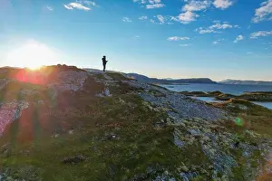 Nordland Prints: Aerial view of a lone figure silhouetted against the bright horizon