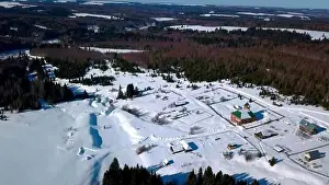 Hoarfrost Prints: Aerial view of lonely houses located in the countryside near dense forest