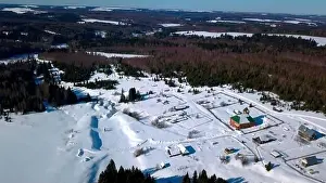 Hoarfrost Prints: Aerial view of lonely houses located in the countryside near dense forest