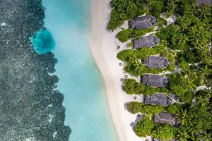 Aerial view on Maldives island. Luxury tropical resort or hotel with beach villas and beautiful beach scenery, coral reef and white sandy landscape