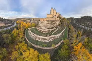 Alcazar Prints: From above aerial view of medieval castle Alcazar of Segovia Spain located on hill with autumn trees next to meandering