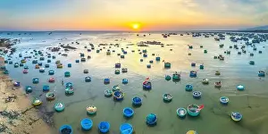 Experiences Prints: Aerial view of Mui Ne fishing village in sunset sky with hundreds of boats anchored to avoid storms