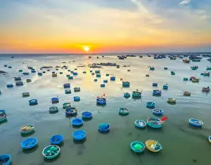 Aerial view of Mui Ne fishing village in sunset sky with hundreds of boats anchored to avoid storms