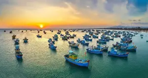 Experiences Prints: Aerial view of Mui Ne fishing village in sunset sky with hundreds of boats anchored to avoid storms