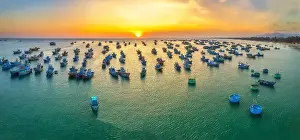 Experiences Prints: Aerial view of Mui Ne fishing village in sunset sky with hundreds of boats anchored to avoid storms