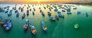 Experiences Prints: Aerial view of Mui Ne fishing village in sunset sky with hundreds of boats anchored to avoid storms