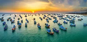 Experiences Prints: Aerial view of Mui Ne fishing village in sunset sky with hundreds of boats anchored to avoid storms