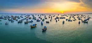 Experiences Prints: Aerial view of Mui Ne fishing village in sunset sky with hundreds of boats anchored to avoid storms