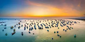 Experiences Prints: Aerial view of Mui Ne fishing village in sunset sky with hundreds of boats anchored to avoid storms