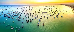 Experiences Prints: Aerial view of Mui Ne fishing village in sunset sky with hundreds of boats anchored to avoid storms