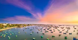 Experiences Prints: Aerial view of Mui Ne fishing village in sunset sky with hundreds of boats anchored to avoid storms