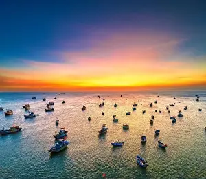 Experiences Prints: Aerial view of Mui Ne fishing village in sunset sky with hundreds of boats anchored to avoid storms