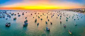 Aerial view of Mui Ne fishing village in sunset sky with hundreds of boats anchored to avoid storms