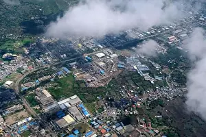 An aerial view of Mumbai's skyline passing over a building with roads and bridges