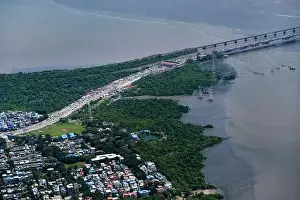 An aerial view of Mumbai's skyline passing over a building with roads and bridges