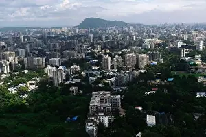 Urban Living Prints: An aerial view of Mumbai's skyline passing over a building with roads and bridges