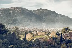 Verdant Prints: Aerial view of old town located near mountain ridge on cloudy day in green countryside of Mallorca
