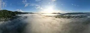 Sunset Sky Prints: Aerial view Panorama of flowing fog waves on mountain tropical rainforest