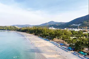 Aerial view of people swimming in the transparent turquoise sea at Karon beach in Phuket, Thailand