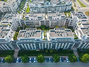 Parking Lots Prints: Aerial view of residential houses neighborhood and apartment building complex at sunset