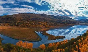 Aerial view of road and lake in beautiful autumn Altai forest