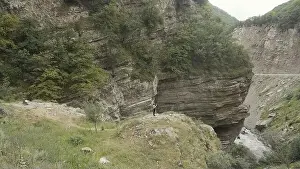 Aerial view of rocks on a summer day on a cloudy sky background. Action. Green forested mountains