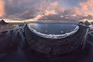 Aerial view of rocky mountains covered with snow located near sea against cloudy sky during sunset in Almeria