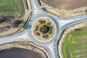 Aerial view of roundabout in countryside with rural, agriculture fields. Circle road: European roundabout around agriculture field with little traffic