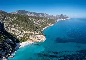 Aerial view of the rugged mountainous coast near Cala Gonone with turqouise water and small white sand beaches