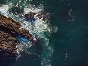 Aerial view. Seascape. Clear turquoise ocean water with white foamy waves and rocky shore