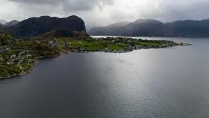Aerial view of a serene fjord landscape with a small village nestled along the shore