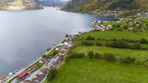 Aerial view of a serene fjord landscape with a small village nestled along the shore