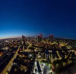 Highways Prints: This aerial view showcases a city's skyline at twilight with buildings illuminated