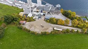 Aerial view of a small factory with solar panels on roof near a fjord in Norway
