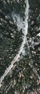 Winter Background Prints: Aerial view of snowy winter forest with a road in austria