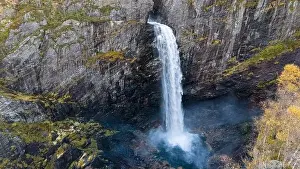 Vale Prints: Aerial view of a stunning waterfall cascading down rocky cliffs into a deep blue pool surrounded by lush greenery