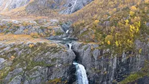 Directly Above Prints: Aerial view of a stunning waterfall cascading down rocky cliffs into a deep blue pool surrounded by lush greenery