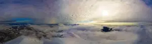 Hill Glacier Prints: Aerial view of the stunning winter panorama of the snowy slopes and hills among the lush white clouds