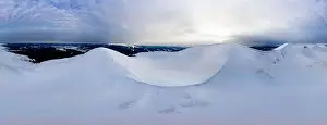 Hill Glacier Prints: Aerial view of the stunning winter panorama of the snowy slopes and hills among the lush white clouds