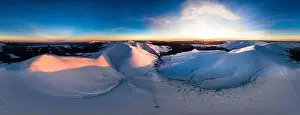 Hill Glacier Prints: Aerial view of the stunning winter panorama of the snowy slopes and hills among the lush white clouds