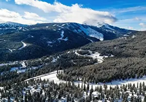 Snowstorm Prints: Aerial view traffic road through the snowy mountains with pine trees